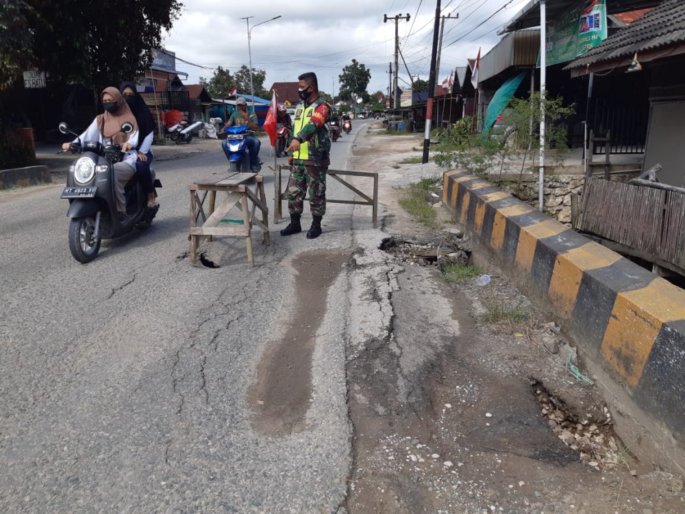 Peduli Keselamatan Umum, Babinsa Babulu Beri Tanda Di Atas Jembatan Berlubang